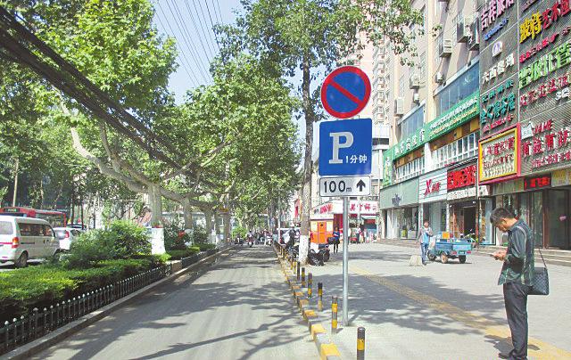 限时一分钟停车标示牌 (本报记者 陈飞波 摄) 原标题:限时停车1分钟缓解拥堵 雁塔交警率先向校园周边交通乱象“开刀” 昨天,交警雁塔大队在全市率先启动校园周边交通设施标准化建设,在位于辖区繁华路段的4所学校开始试点,其中设立限时停车1分钟标识等6项措施,受到师生及家长好评。 昨天下午两点,在翠华路小学门前,陆续步入校门的同学和前来送孩子上学的家长们,对校门口道路上的一些小变化都非常好奇。今年上五年级的小可对妈妈说:“我之前在iPad上看到过交警叔叔做的微电影,这个黄