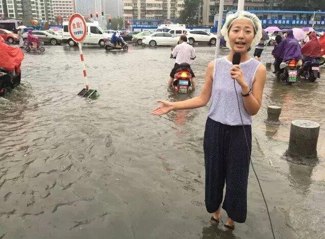 郑州:女主播浑身湿透 戴浴帽直播暴雨 - 中国网