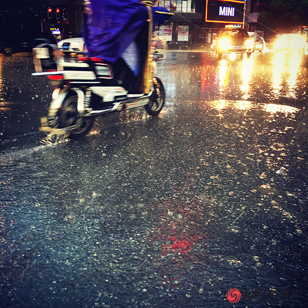 行人雨中骑车 图/郑清雄