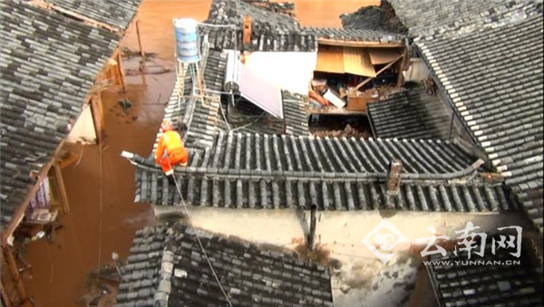 云南一村庄遭遇暴雨 消防官兵屋顶跪行背出老人