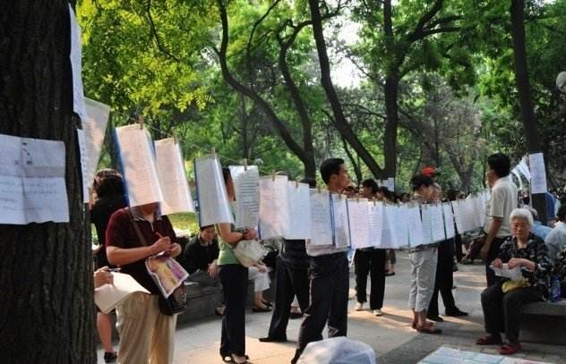 假日中山公园相亲火爆 父母上阵举牌但不主动搭话