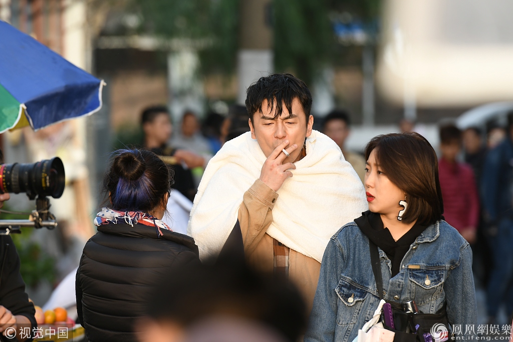 雷佳音拍戏惨成"落汤鸡 街头抽烟御寒