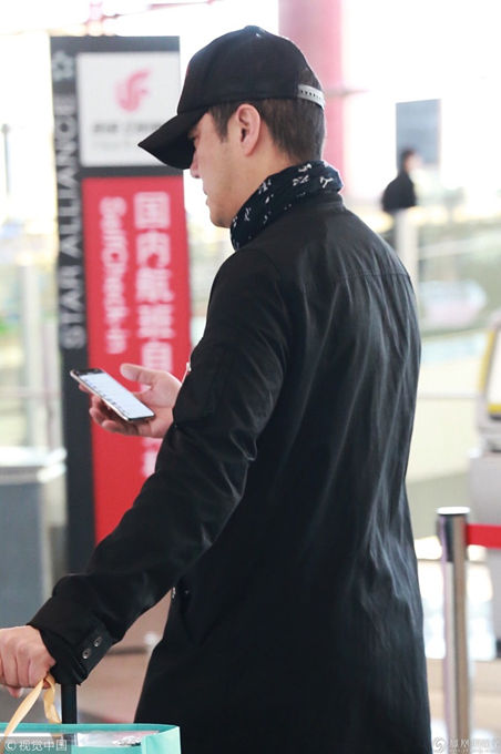 李亚鹏亮相机场 黑衣低调手机刷不停
