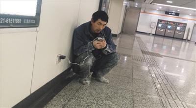 上海地铁口“蹭网”农民工：不舍买流量，又想家