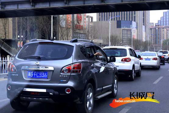 一位乘客从行驶的汽车车窗扔出垃圾 长城网 张世豪 摄高清图片