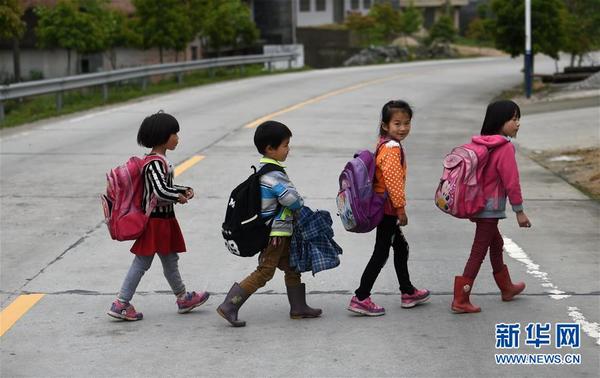 4月27日,放学后彭逸(右一)和同学们一同排队过马路。新华社记者 李尕摄