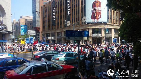 5月1日上午,南京路步行街,通往上海热门景点外滩方向的道路人流量更是密集,不少协警在维持着交通秩序。(邬迪摄)