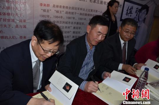 中国象棋特级大师胡荣华、本书作者傅剑仁、本书传主李来群为读者签名。 胡彤亮 摄