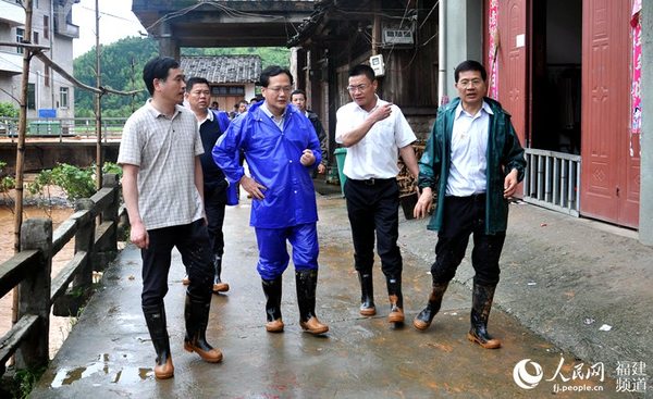 福建省委常委、政法委书记陈冬（前左二）深入现场了解小湖镇下墘村受灾情况。邓忠卫摄