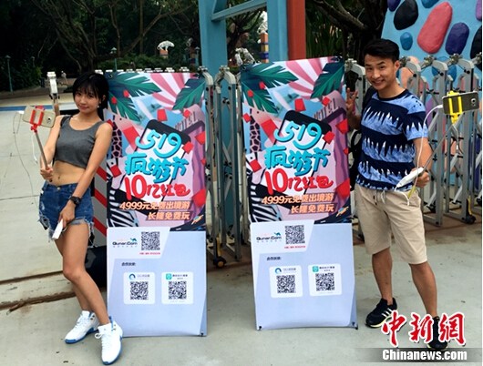 在长隆欢乐世界门口 两位主播和主办方活动海报合影