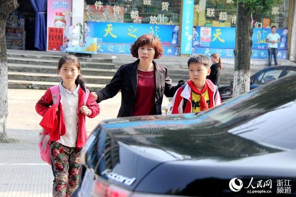 马路上车来车往，有了社工的亲自接送后，家长们放下了心中的担忧。张丽玮 摄