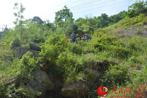 在康县，斜坡村施工人员正把架线工具和材料扛到山上 （刘海天 摄）