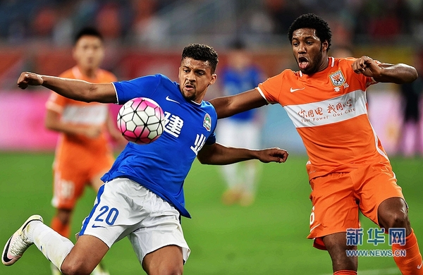 5月21日,河南建业队球员奥斯曼(前左)在比赛中争球。 当日,在2016赛季中国足球超级联赛第10轮比赛中,山东鲁能队在济南主场以0比0平河南建业队。 新华社记者朱峥摄