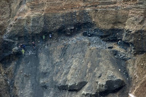 2015年10月，缅甸北部一处玉矿旁边,人们在挖掘机丢弃的废料中寻找玉石。（资料图）