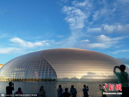 资料图：2015年6月12日，北京市民及游客纷纷拍摄蓝天白云映衬下的国家大剧院。金闻 摄 图片来源：CFP视觉中国