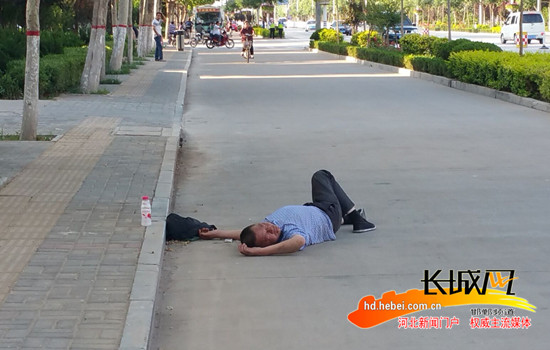 醉汉仰睡在马路上。