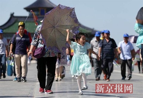 小女孩打伞游览。新京报记者 薛珺 摄