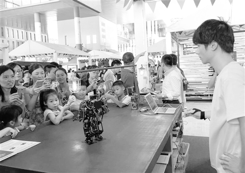 在日前举办的深圳创客周上，人们在饶有兴趣地欣赏机器人产品。经济日报记者 金晶 摄