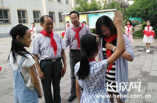 同学们为嘉宾们戴上红领巾。孙向向 摄