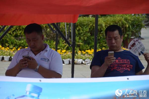 南昌二中的考点外，家长们在阴凉处等待首场考试结束。