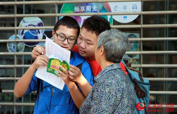 6月7日上午，云大附中考点外，两考生正查看高考资料。（人民网 虎遵会 摄）