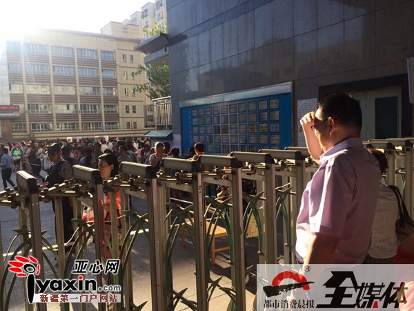 6月7日8时30分，乌市兵团二中高考考点 学生家长看着孩子进入考场。
