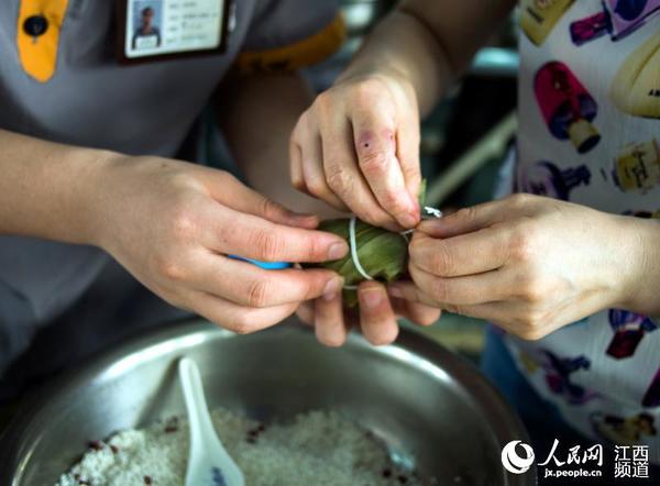 端午节前夕,江西省未管所邀请百名母亲走进监狱和自己的孩子一起包粽子,庆佳节。(李斌/摄)