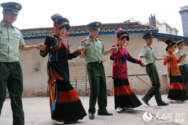 武警四川省总队凉山州支队七中队官兵和彝族老乡一起跳达体舞欢度端午节。（李结义 摄）