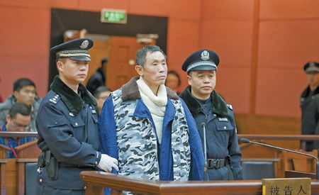 2014年1月13日,被告人范杰明(中)在法庭上