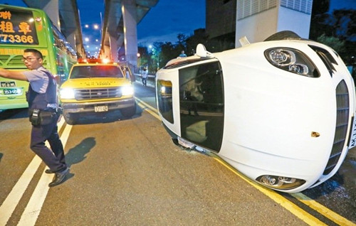 保时捷休旅车失控擦撞护栏后翻覆。(图:台湾《联合报》/许正宏)
