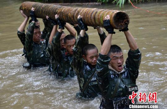 6月24日，武警福建省总队龙岩市支队特战队员在水中进行托举圆木训练，挑战体能极限。(苏高龙 摄) 苏高龙 摄