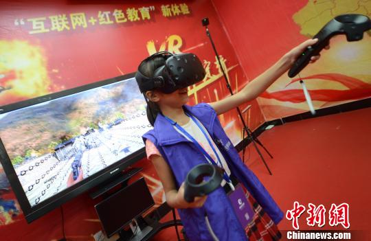 一名女孩带上VR体感交互设备及眼镜，沉浸式体验红军长征中的“飞夺泸定桥”战斗场景。　记者刘可耕 摄