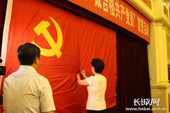 省委常委、宣传部部长田向利在党旗上签名。 长城网 张欣 摄