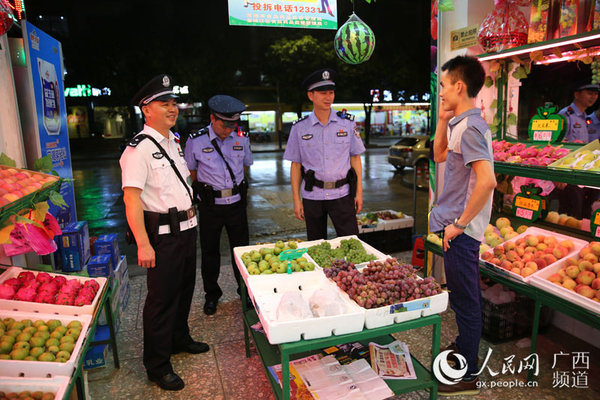 罗期权与水果店店主交谈社会治安情况,听取市民对公安机关的意见