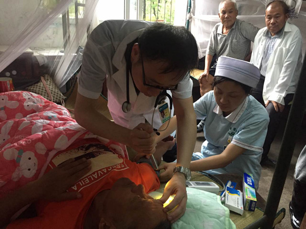医生为身患肺癌的灾民做全身检查，并指导其服用镇痛药