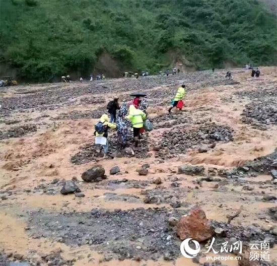 丽宁公路部分路段发生塌方及泥石流，造成道路中断。交警正转移被困人员。（许强 摄）