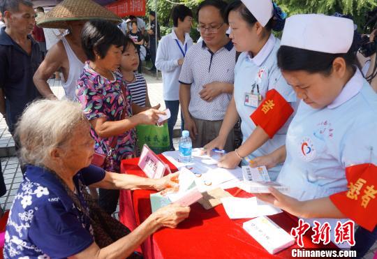图为志愿者为看病民众赠药。　赵琳露　摄
