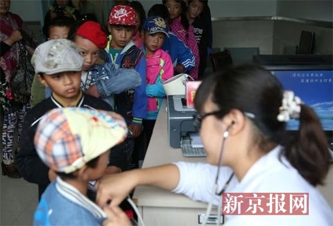 专家在为当地先心病疑似患儿检查。新京报记者 薛珺 摄