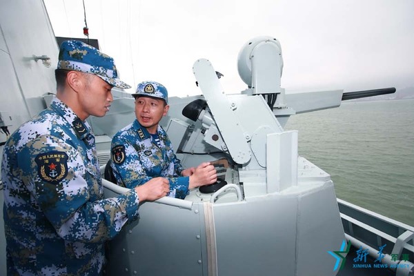 范文武（右）在宿州舰副炮手研究新装备。（2016年7月1日摄）新华社记者 查春明摄
