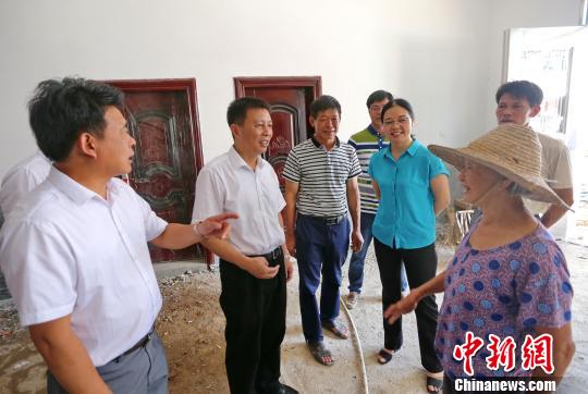 图为连城县委书记钟勇强(左二)、代县长吕素梅(右二)到天马村走访受灾重建户。　黄水林 摄