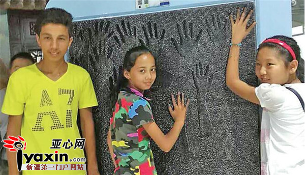 再比尔丁·克尤木（左）、夏依达·吾甫尔（中）和陈佳烨（右）在科技馆一起体验针幕