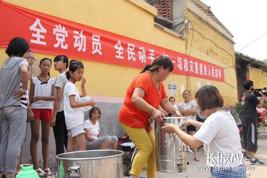 村民自发组织为义务劳动队熬煮绿豆汤解暑。 高琳哲 摄
