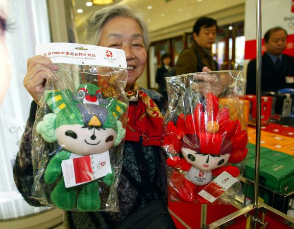 资料图片：2005年11月12日，在北京王府井百货大楼内，一名顾客展示自己购买的奥运会吉祥物。 新华社发
