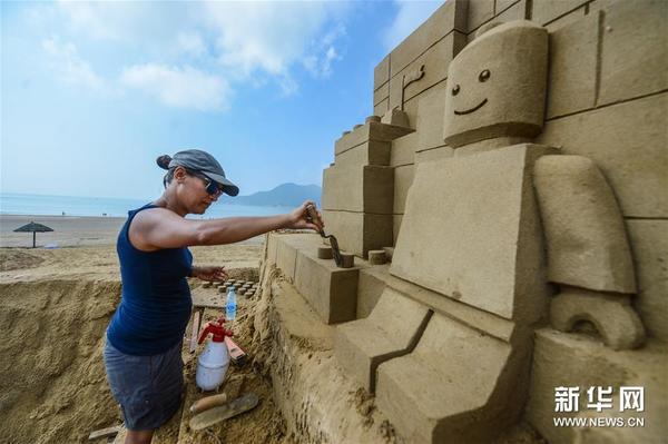 8月25日，来自荷兰的女沙雕手安妮克正在创作玩具积木主题的沙雕。