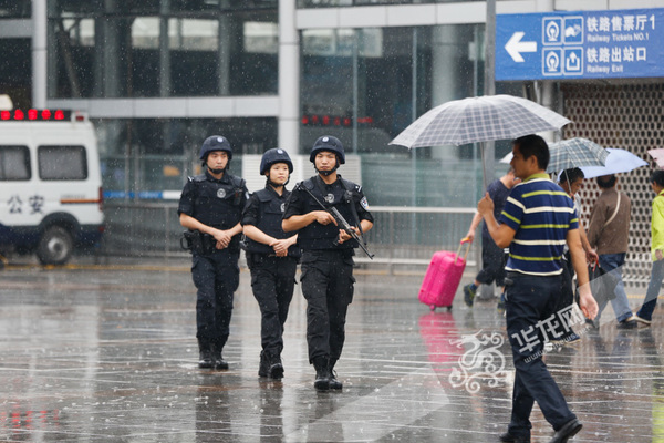 特警队员在雨中巡逻，因为雨衣雨具会妨碍警用装备的操作，所以他们下雨巡逻时不会穿雨衣或者打伞。记者 石涛 摄