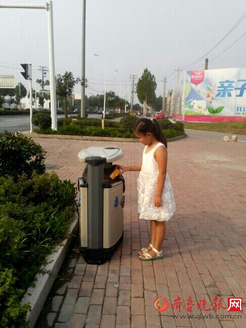 暖心!济宁小学生路边捡垃圾放到垃圾箱