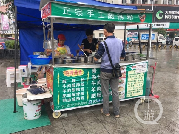 清晨,胡道柏一家三口在广场上卖酸辣粉(背对镜头的是父亲)。