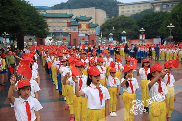 少先队员们唱起了《歌唱祖国》、《我们是共产主义接班人》等红色歌曲，并挥动着手中的小国旗 记者 刘嵩 摄