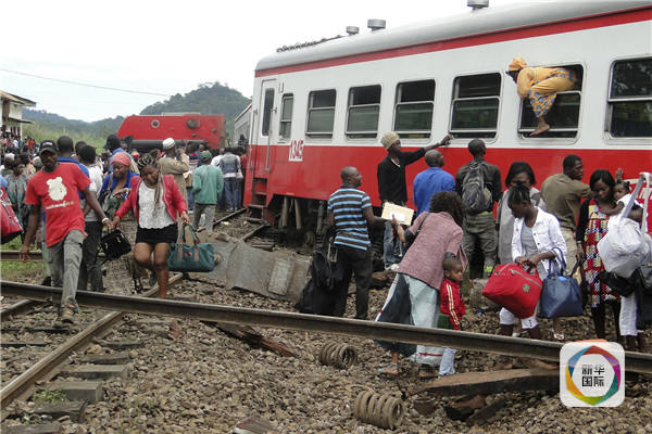 　　10月21日，在喀麦隆埃塞卡，一名乘客从脱轨火车的一扇窗户逃生。（法新社）