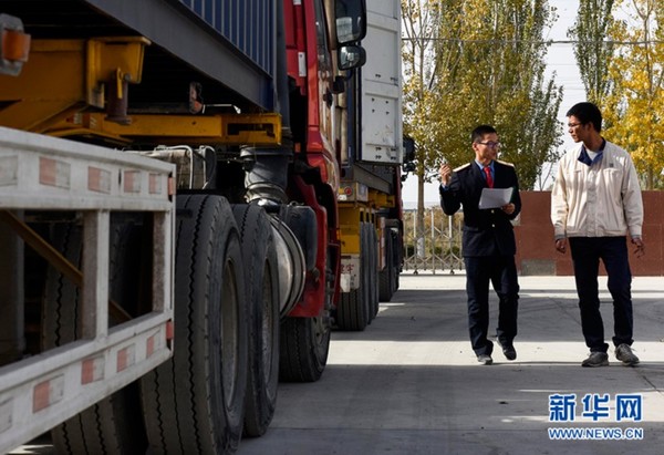 在阿拉尔飞龙纺织有限公司内，乌鲁木齐铁路局喀什货运中心工作人员与公司员工对接集装箱运输方案（10月23日摄）。